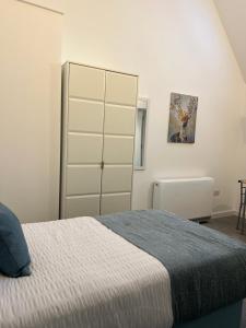 a bedroom with a bed and a tall cabinet at 12 Plants Yard -Modern Retreat in Worksop