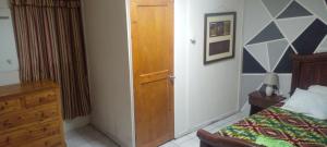 a bedroom with a bed and a wooden door at Aracari Inn Mindo in Mindo