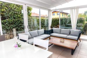 a patio with a couch and a table and chairs at Villa Orchidea in Franciacorta in Villa Pedergnano