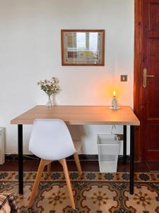 a wooden table with a white chair in a room at La Casa di Eli in Pisa