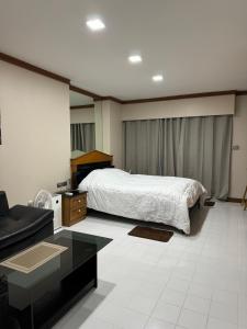 a bedroom with a bed and a couch and a table at Bitec Bangna Bkk in Bangkok