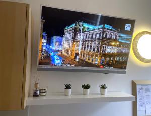 einen Flachbild-TV, der an einer Wand hängt in der Unterkunft Stylish home near city center in Wien