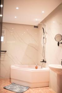 a white bathroom with a tub and a sink at Munir’s residence in Cairo