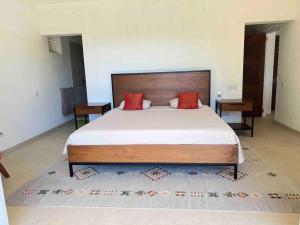 a bedroom with a large bed with red pillows at Aruanda Apartment - perfect get-away for two at the top of Bequia in Union