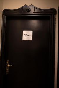 une porte noire avec un panneau indiquant la thérapie dans l'établissement Munir’s residence, au Caire