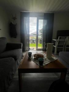 ein Wohnzimmer mit einem Couchtisch vor einem Fenster in der Unterkunft Norra Sandby, lantlig njutning in Norra Sandby