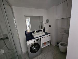 a bathroom with a washing machine and a sink at Orbi apartament in Batumi