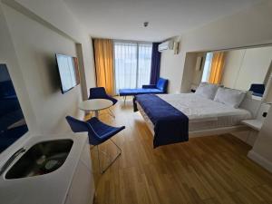 a hotel room with a bed and a sink at Orbi apartament in Batumi
