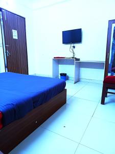 Hotel S-14 في جايبور: غرفة نوم بسرير وتلفزيون وكرسي