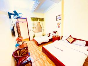 Xuân ÐàiにあるLam Hong Hotelのベッド2台と椅子が備わる客室です。