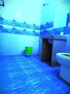 a bathroom with a toilet and a green trash can at Hotel S-14 in Jaipur