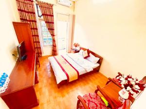 a bedroom with a bed and a table and a chair at Lam Hong Hotel in Xuân Ðài