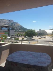 a bed on a balcony with a view of a street at sunny apartments near the sandy beach in Omiš