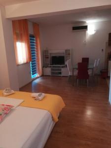 a bedroom with a bed and a table and chairs at sunny apartments near the sandy beach in Omiš