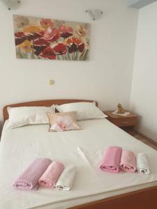 a white bed with three pink towels on it at sunny apartments near the sandy beach in Omiš
