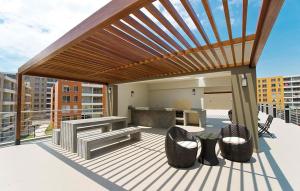 a wooden pergola on a deck with chairs and a table at Departamento VIP estreno en Condominio in Lima