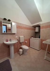 bagno con lavandino, servizi igienici e specchio di apartment in the center of Castellammare del Golfo a Castellammare del Golfo