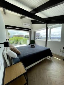 a bedroom with a large bed and large windows at Casa Albuerne in Gijón