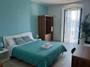 Duomo Guest House في بارليتا: غرفة نوم زرقاء مع سرير ولحاف أخضر