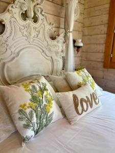 białe łóżko z poduszkami ze słowem miłość w obiekcie Cabaña Romántica w mieście Collantres
