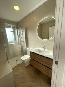 a bathroom with a sink and a toilet and a mirror at Casa Albuerne in Gijón +34 photos