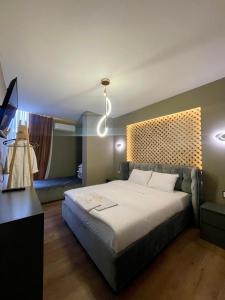 sypialnia z dużym łóżkiem i lampką w obiekcie GRAND JNK Boutique Hotel w mieście Kukës