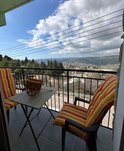 een balkon met 2 stoelen en een tafel met uitzicht bij Chambous house in Kelokedhara