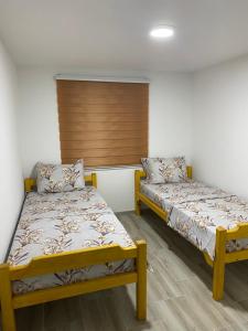 two beds in a room with white walls at Bibex Komplex in Gornje Međurovo