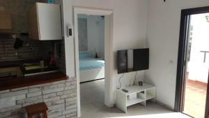 un soggiorno con TV e una camera con letto di Appartamento Corallo a Costa Del Silencio