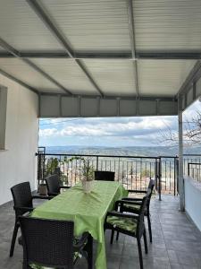 una mesa verde y sillas en un patio con vistas en Chambous house, en Kelokedhara