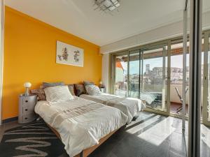 カンヌにあるAGENCIA appartement 2 chambres au Suquetの黄色い壁の客室内のベッド2台
