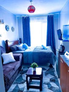 a living room with a bed and a couch at Sarah's Studio in Kiambu