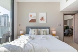 a bedroom with a large white bed with two towels at GuestReady - A Sigh of Bliss in Dubai