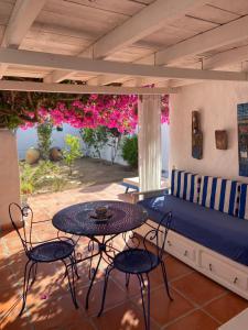 a patio with a couch and tables and flowers at RESIDENCE DAR YASMINa in Mezraya