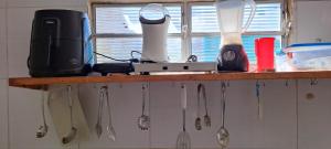 un estante con utensilios en la cocina en Flat em Itamaracá en Itamaracá