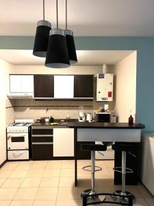 a kitchen with black and white appliances and a counter at Cerca de todo! Ubicación estratégica in Godoy Cruz