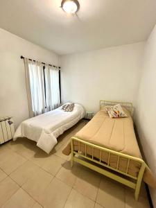 two beds in a small room with a window at Cerca de todo! Ubicación estratégica in Godoy Cruz