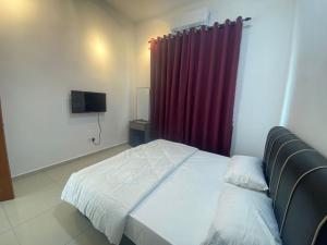 a bedroom with a bed and a red curtain at KSP Guest House in Melaka