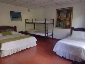 um quarto com duas camas e um quadro na parede em Ecohotel La Casona em Pereira