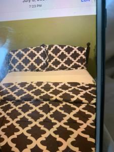 a bed with a black and white comforter and two pillows at Ottawa Heritage Room Across OttawaU in Ottawa