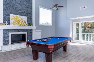 a living room with a pool table and a fireplace at Escape To Island Bay - Walk To Moody Gardens in Houston