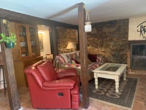 sala de estar con silla roja y mesa en Patones de Arriba, en Patones