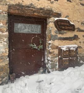 una puerta a un edificio con nieve en el suelo en Patones de Arriba, en Patones