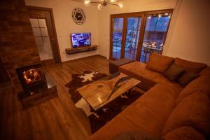 un soggiorno con divano e camino di Villa Rexhes a Ferizaj