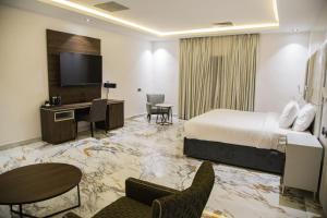 Habitación de hotel con cama y escritorio en The Safron Hotel en Lagos