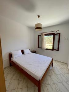 sypialnia z dużym łóżkiem i oknem w obiekcie Palamari Skyros w mieście Skiros