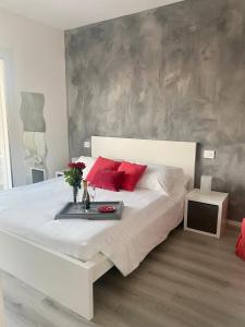 - une chambre avec un grand lit blanc et des oreillers rouges dans l'établissement Villa Carlotta, à Salionze