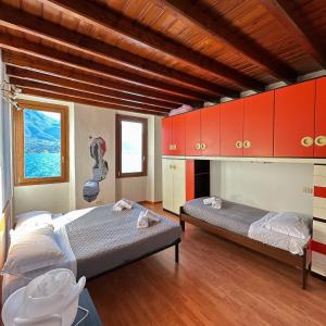 Oliveto Larioにあるrenzo e Lucia lake view apartmentの赤いキャビネット付きの部屋のベッド2台