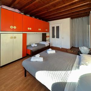 Oliveto Larioにあるrenzo e Lucia lake view apartmentのオレンジと白のキャビネット付きの客室内のベッド2台