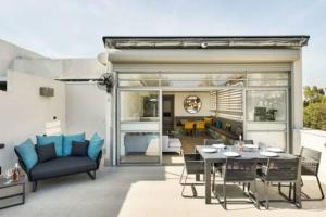 a patio with a table and chairs and a living room at Peaceful Terrace by Five Stay in Tel Aviv